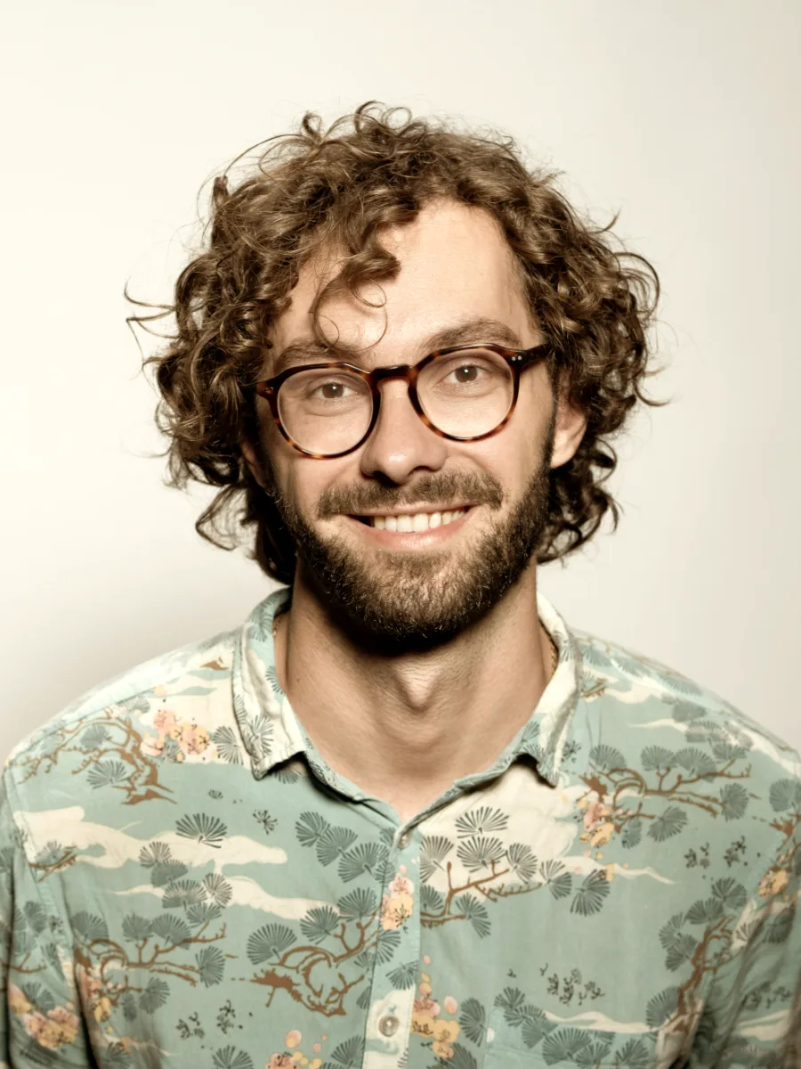 Smiling man with glasses in a printed short-sleeve shirt